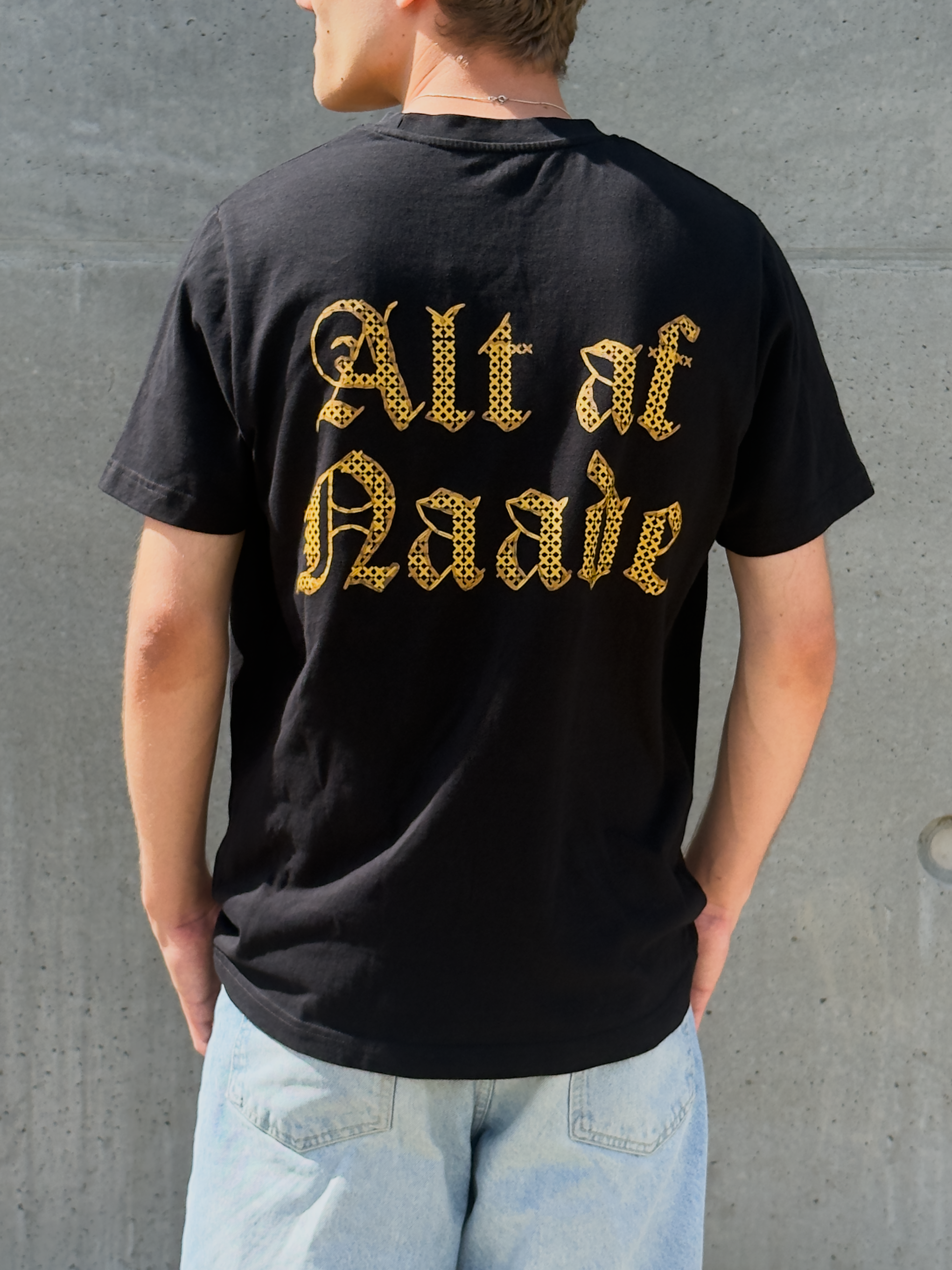 Alt af Naade – sort kristen T-shirt set bagfra med Alt af Naade i gotisk korsstings-print