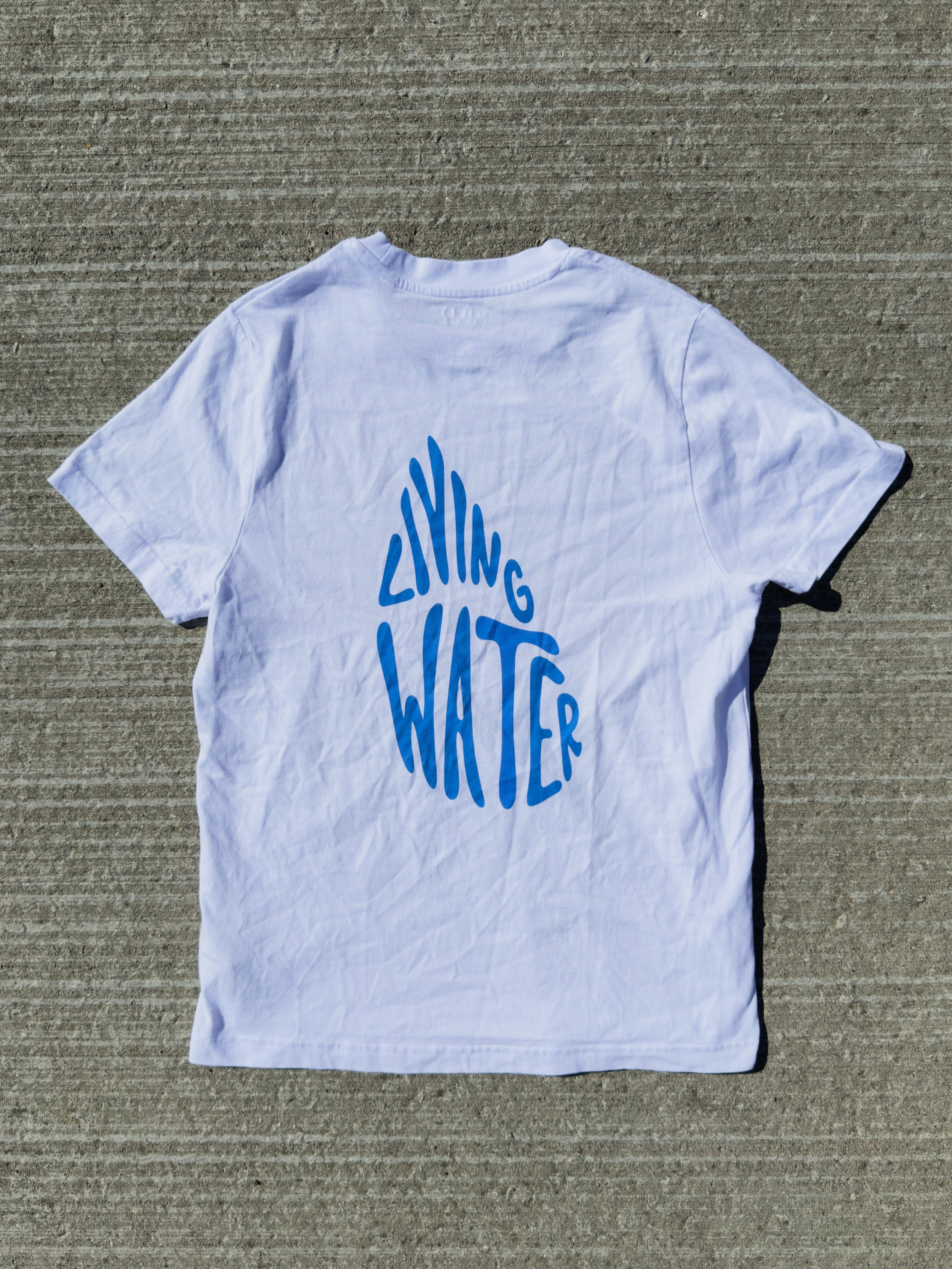 Living Water – hvid kristen T-shirt liggende med dråbeformet Living Water-rygprint